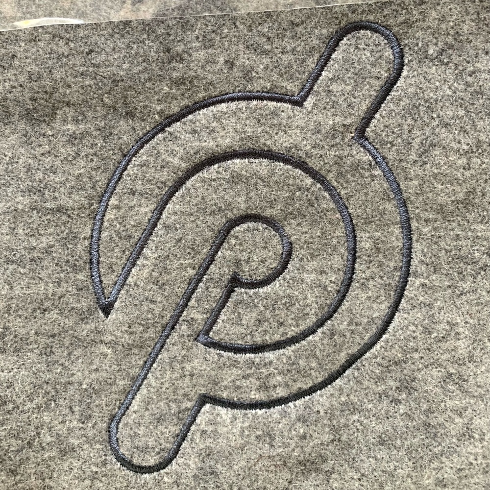 Peloton “P” embroidered grey, wool blend throw blanket.
